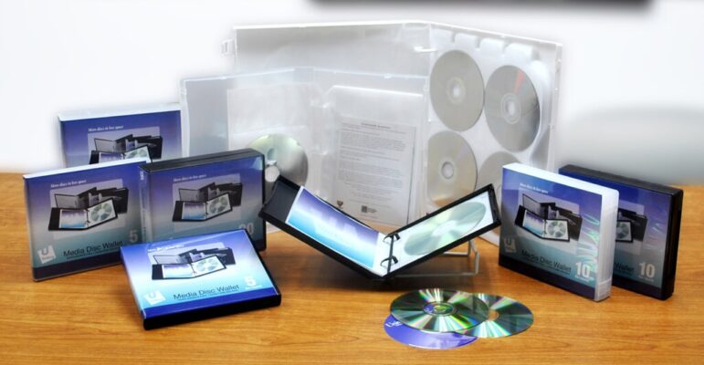 A DVD case surrounded by DVDs and CDs neatly arranged on a table, showcasing a collection of media items.