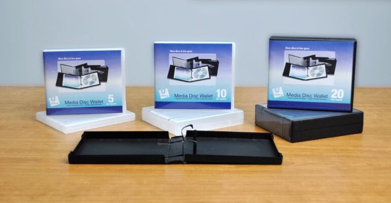 Three blank DVD cases arranged neatly on a table, showcasing their empty, unmarked surfaces.
